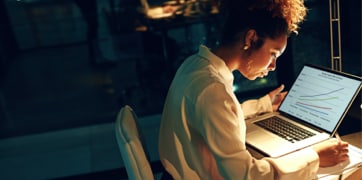 Una mujer sentada frente a una computadora portátil